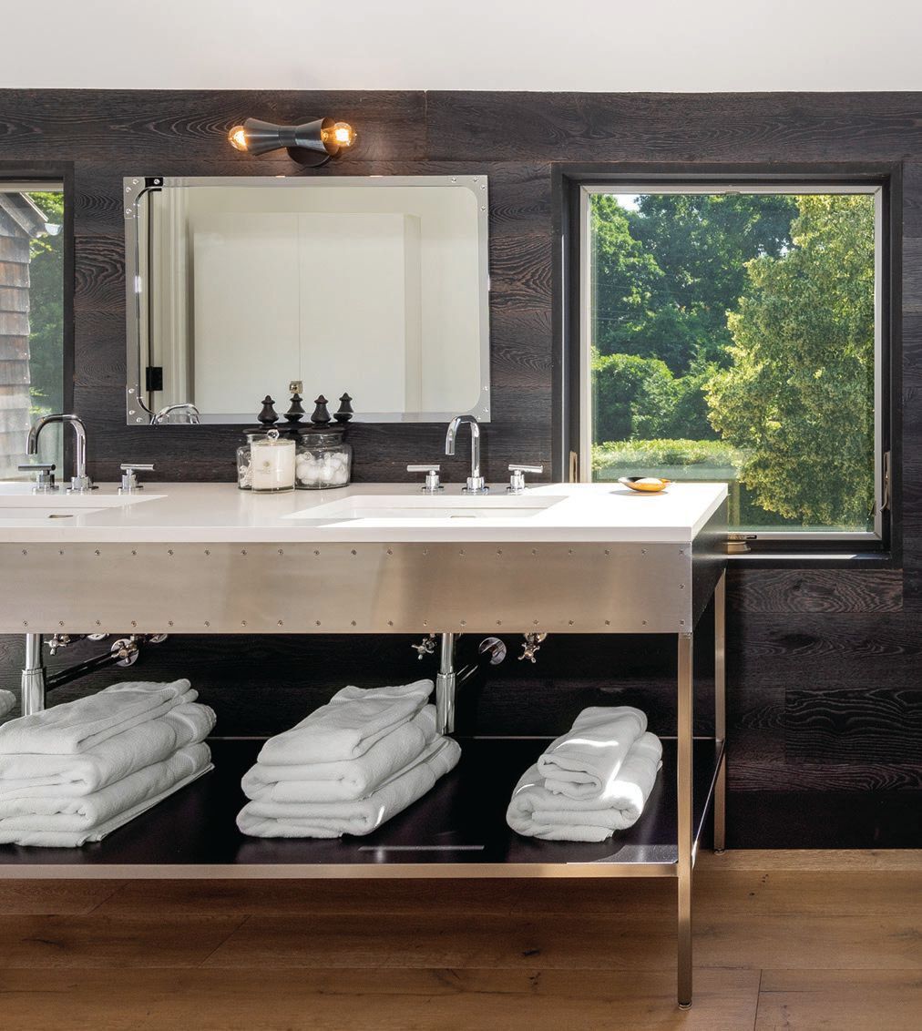 A custom MARKZEFF sink finished with stainless steel sits in front of black
wood clapboarding with a pair of windows cut into it. PHOTOGRAPHED BY TIM WALTMAN