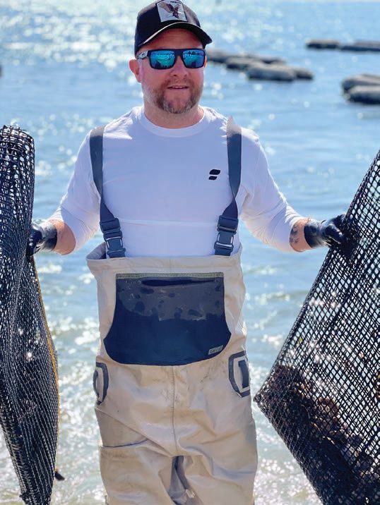Jeff Ragovin with his oyster mesh bags coming out of the water RAGOVIN PHOTO BY JENNA GOLDRING