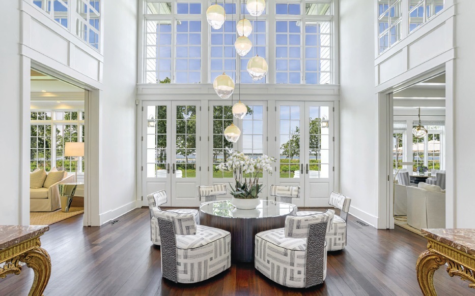 From the first foot in, guests are greeted with an eye-catching light fixture from Global Views and a vintage Lucite center table from Guy Regal Ltd. PHOTO COURTESY OF LIFESTYLE PRODUCTION GROUP, LLC