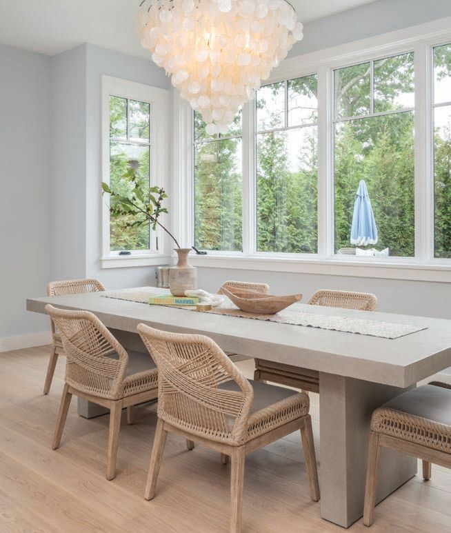 Grand light fixtures steal the show above a dining table PHOTOGRAPHED BY TIM HILL