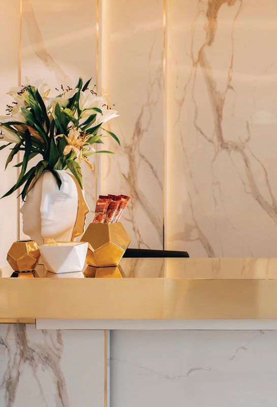 The reception desk gleams with Italian Calacatta gold marble, strips of brass inlay and a solid brass reception desk counter PHOTO COURTESY OF DR. NEINSTEIN
